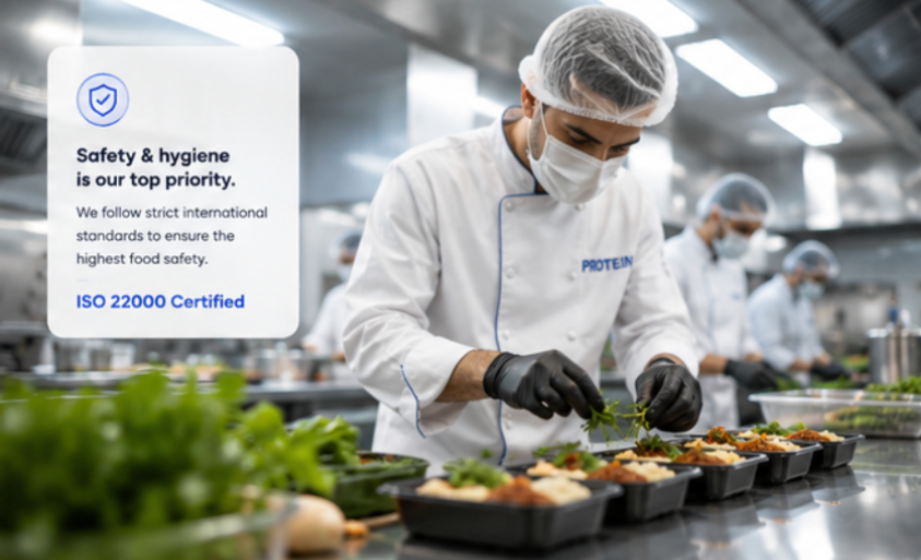 Chefs in protective clothing plating meals in the Protein stainless-steel kitchen
